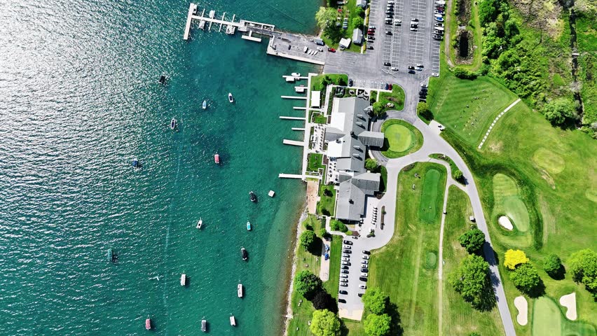 Various boats are floating in the water along the coastline.