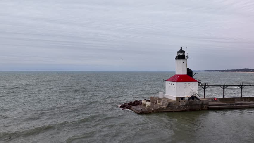 St. Joseph North Pier Lighthouse on Lake Michigan with gray water and an overcast sky.