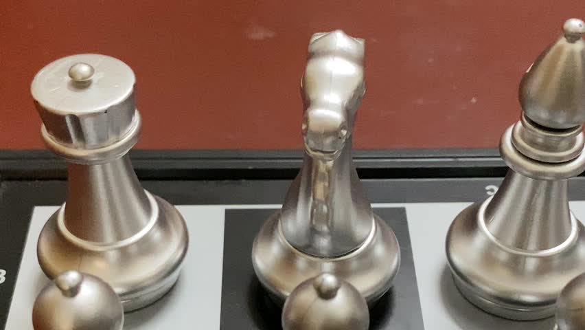 Intellectual chess game board arranged with silver pieces on chess board - close up short.