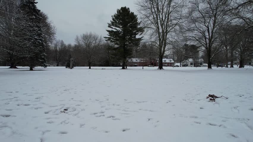 Drone shot of a park after a snowfall in Andover, below the trees on a freezing weather, North Andover Massachusetts