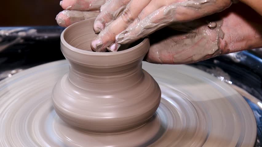 Man makes a clay pot or vase on a potter