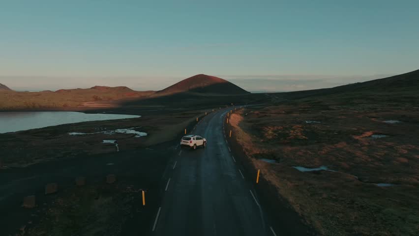 4K Drone Following Car Driving on Scenic Road in Iceland at Sunset Cinematic Aerial Shot