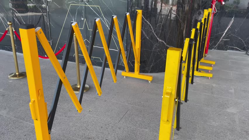 Portable Folding Barricade with Queue Stanchions Outside Building
