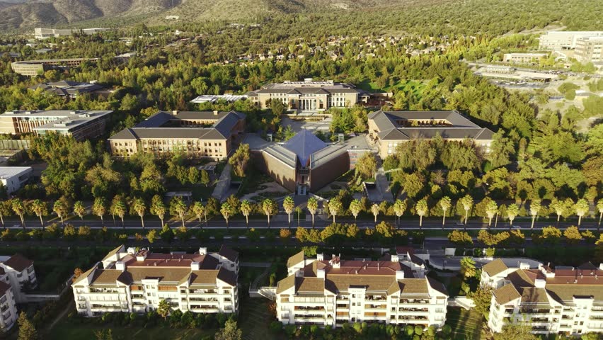 Cinematic aerial tracking shot moving forward over the Universidad de los Andes campus, showing academic buildings and residential areas in Santiago, Chile, 4K