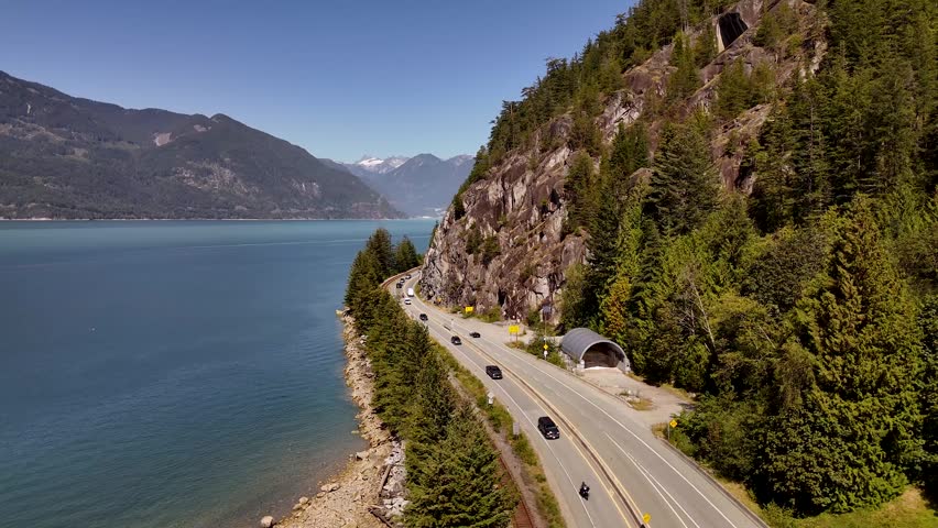 Majestic cinematic drone flyover of the Sea to Sky Highway winding through coastal road between Vancouver and Whistler, British Columbia, Canada. Road trip in Canada. Rocky mountains. 4k footage
