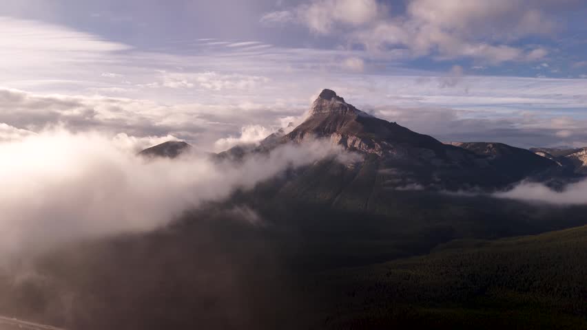 Majestic mountain peak covered in the clouds near Banff National Park, Alberta, Canada. Road trip in Canada. Rocky mountains. 4k footage