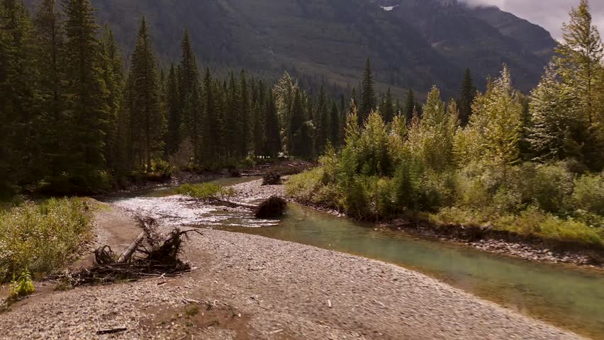 Majestic mountain peaks along the river between Banff and Jasper National Parks, Alberta, Canada. Flight over the river. Road trip in Canada. Rocky mountains. 4k footage