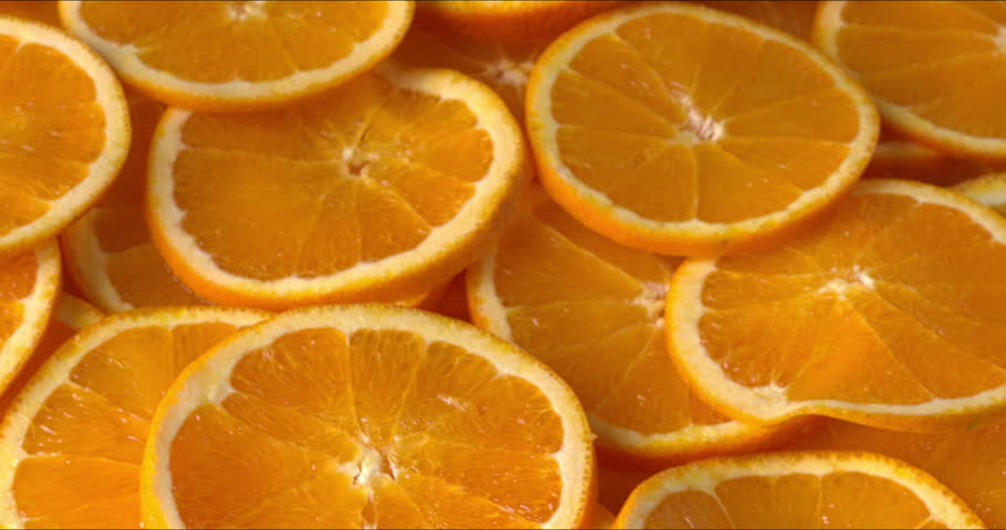 Unpeeled orange slices. Selective focus, table spin.