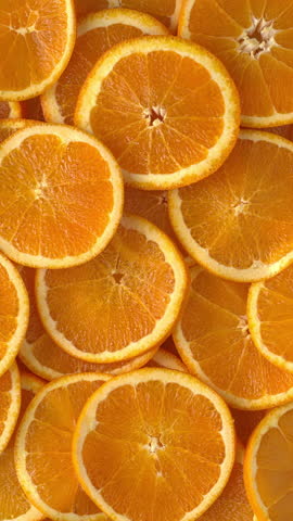 Top view of unpeeled orange slices as a background texture. Vertical video.