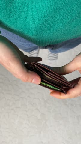 Hands take out a lot of hundred-euro bills from the wallet, top view.