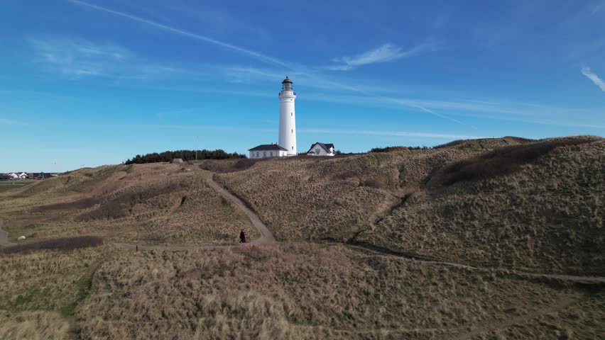 Drone aerial view of Hirtshals Lighthouse on sunny day showing coastal cliffs and North Sea in Nordjylland Denmark for travel tourism commercial use