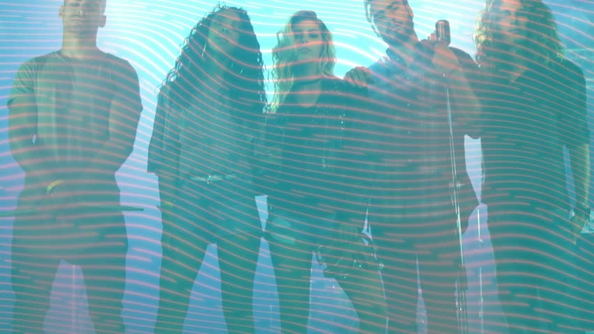 Standing five performers shifting at low studio angle, holding handheld mic, dark tops, teal waves. Ensemble, musicians, stage, performance, projection, lighting, gradient