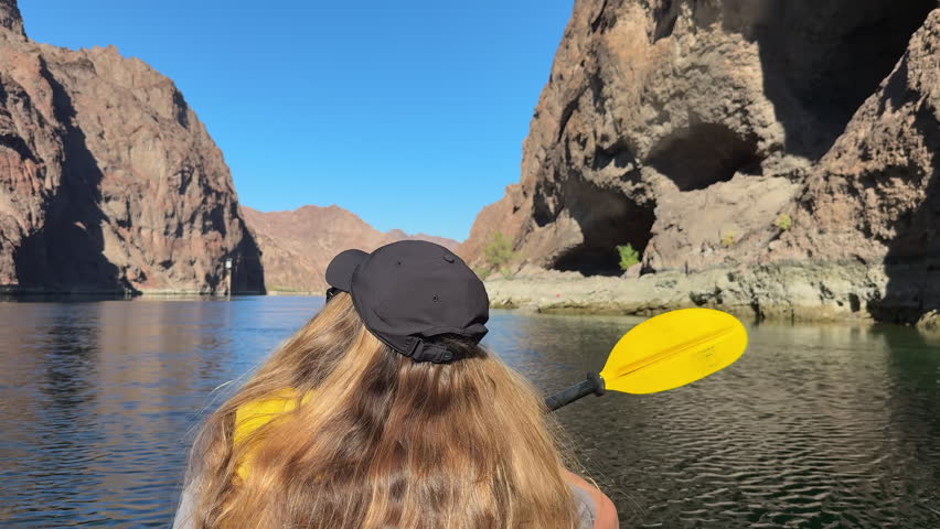 Girl kayaking on Colorado River near Hoover Dam, paddling through Black Canyon.