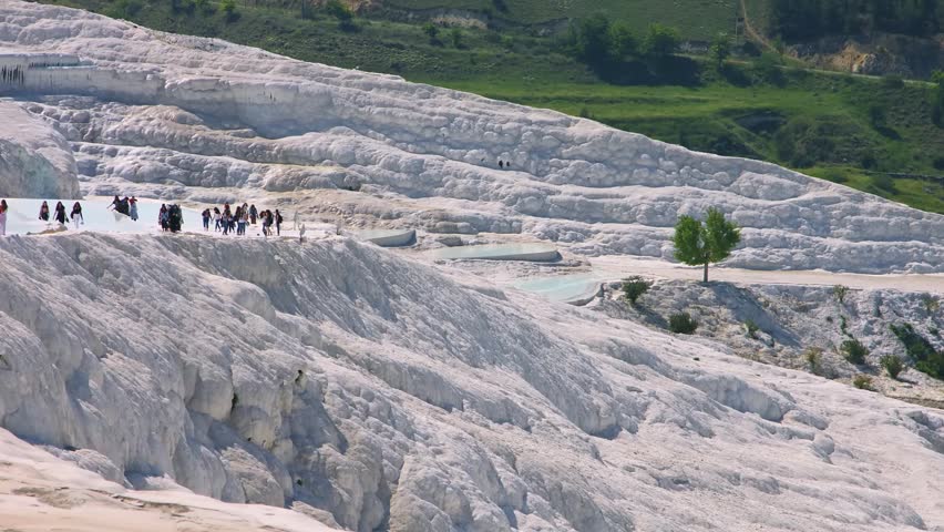 Pamukkale, also known as the "Cotton Castle," captivates with its unique white travertine terraces formed by mineral-rich thermal waters cascading down the hillside. This cinematic footage captures to