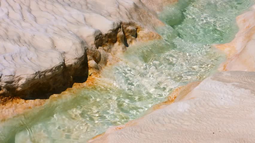 Pamukkale, a UNESCO World Heritage site in Turkey, features stunning natural white terraces formed by mineral-rich hot springs depositing carbonate minerals over millennia.