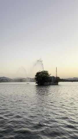 Vertical view of a gentle fountain spray in the middle of a calm water body.