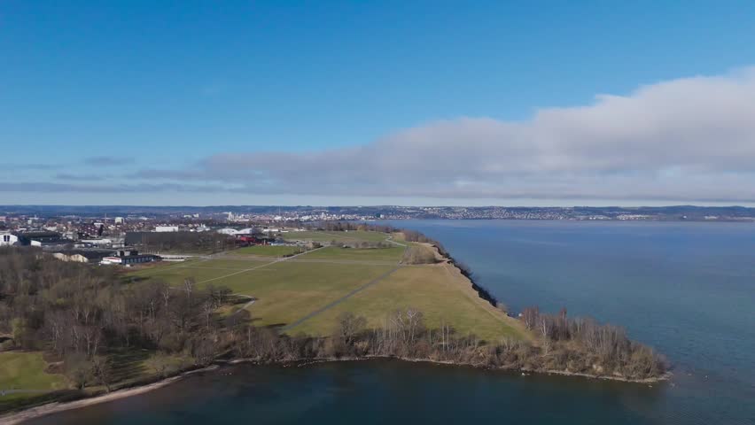 Aerial View of Coastal Landscape and Cityscape, Aerial drone shot of a coastal city skyline next to a wide blue bay.