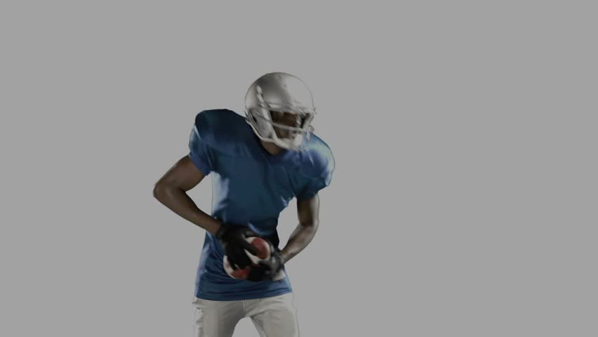 Football player shifting grip winding throwing ball for ad panels behind showing File ENCRYPTION. Quarterback, athlete, helmet, pads, gloves, pass, windup