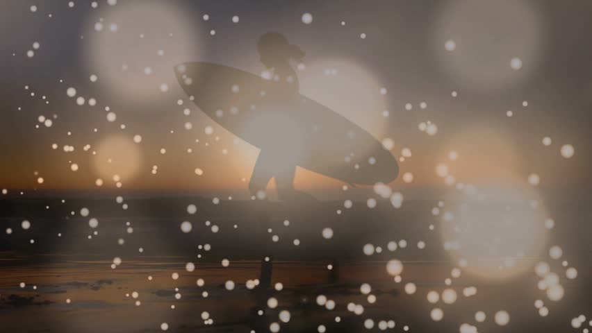 Female surfer carrying board walking at sunset, drifting bokeh over board and sand glow travel. Silhouette, shoreline, horizon, twilight, ocean, reflections, stride
