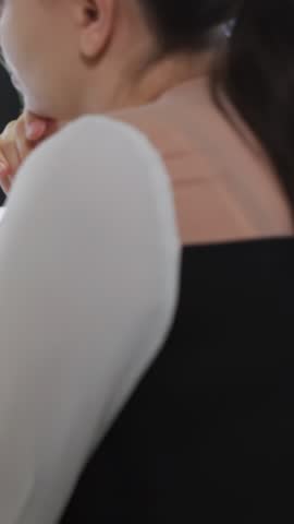 Vertical video: Streaming host holding chin, watching follower badges popping up, tracking growth. Studio, portrait, influencer, overlay, notifications, metrics, vertical video