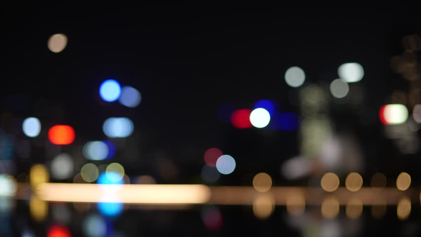 Cinematic defocused view of the modern night skyline in Shenzhen, China. Soft bokeh circles from city skyscrapers and urban lights.