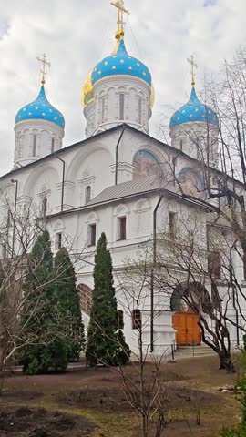 Cathedral of Transfiguration in Novospassky Monastery in Moscow, Russia. Ornate Russian Orthodox church features blue domes and golden crosses under a clear sky in Moscow. Historical monument