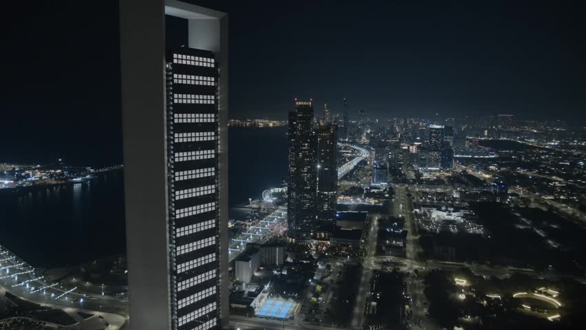 Stunning timelapse of Abu Dhabi skyline at night captured from a high floor vantage point. Illuminated skyscrapers, dynamic city lights, and traffic motion create a vibrant urban atmosphere in the capital of the UAE. Modern architecture, luxury lifestyle, and futuristic cityscape in the Middle East.