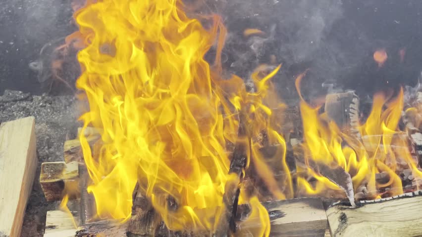Burning firewood with cinematic flames and glowing embers close up, abstract fire texture background, HDR Dolby Vision 4K high dynamic range footage