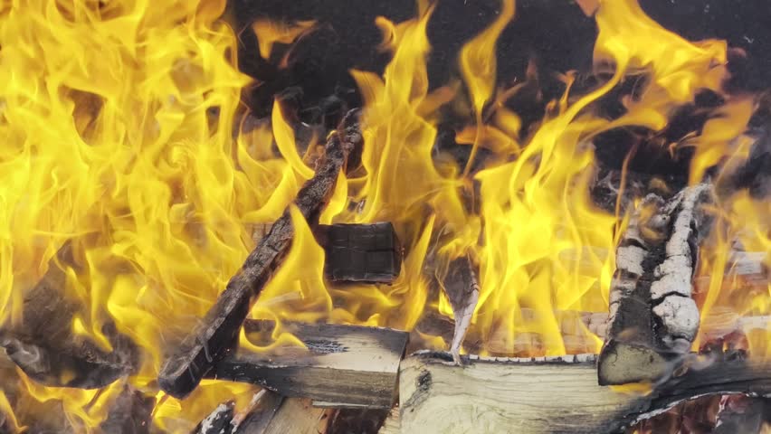 Burning firewood with cinematic flames and glowing embers close up, abstract fire texture background, HDR Dolby Vision 4K high dynamic range footage