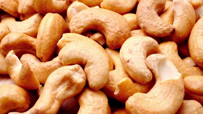 Close up of roasted cashew nuts showing golden crunchy texture with rich natural color and detailed surface highlighting healthy snack concept in soft lighting and appetizing food background