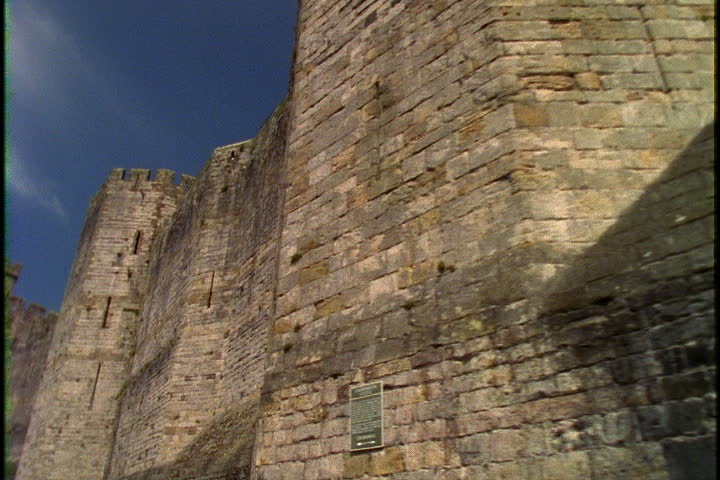 Camera tracks along high stone walls of Caernafon Castle in Gwynedd, North-West Wales.