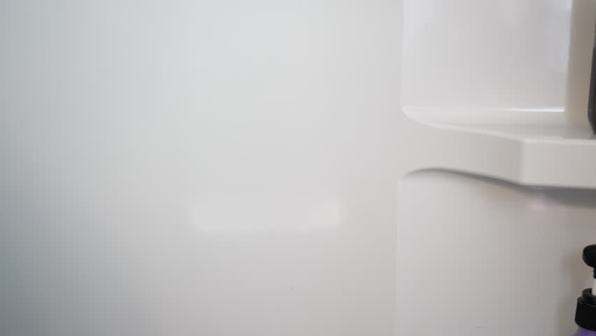 Hand installing suction cup grab handle inside a stand-up shower stall for bathroom safety and accessibility. Home safety and senior assistance concept. 15112  