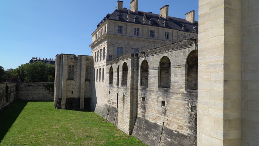 Defensive medieval stone walls and tower of Vincennes Castle on a sunny summer day, Paris, France.
