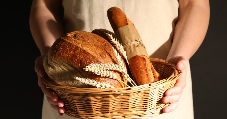 Woman with different types of bread on dark background, closeup