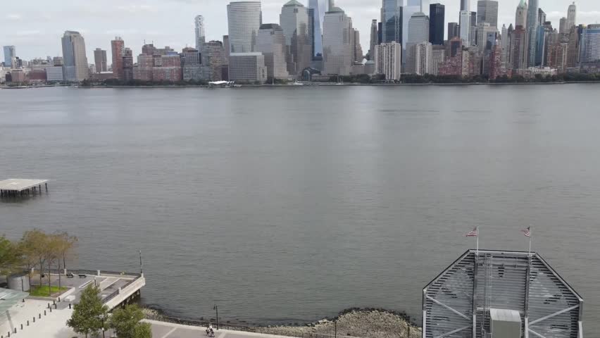 Scenic view of the Lower Manhattan skyline and One World Trade Center across the Hudson River on a cloudy day.