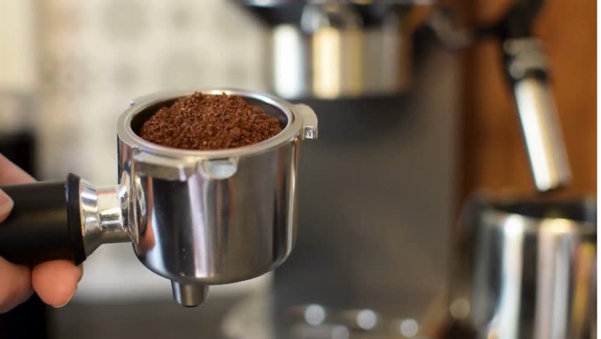 Closeup of hand holding espresso machine
