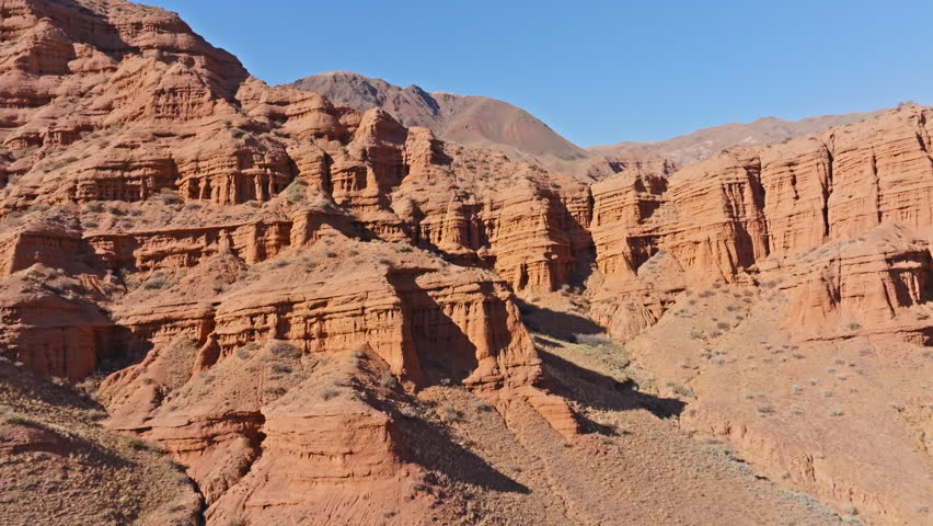 Aerial view captures stunning sandstone rock formations in remote desert canyon. Majestic landscape showcases natural beauty and arid environment.