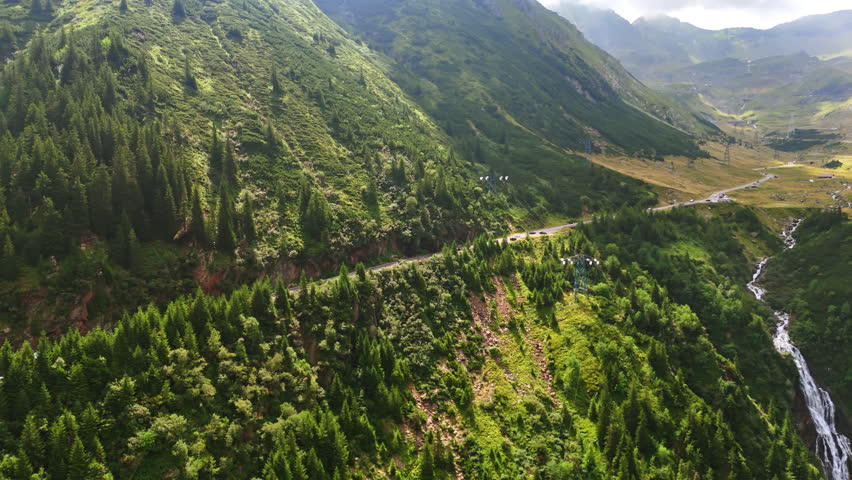 Amazing scenery of green mountains with a beautiful waterfall. Aerial perspective on the stunning nature of Romania.