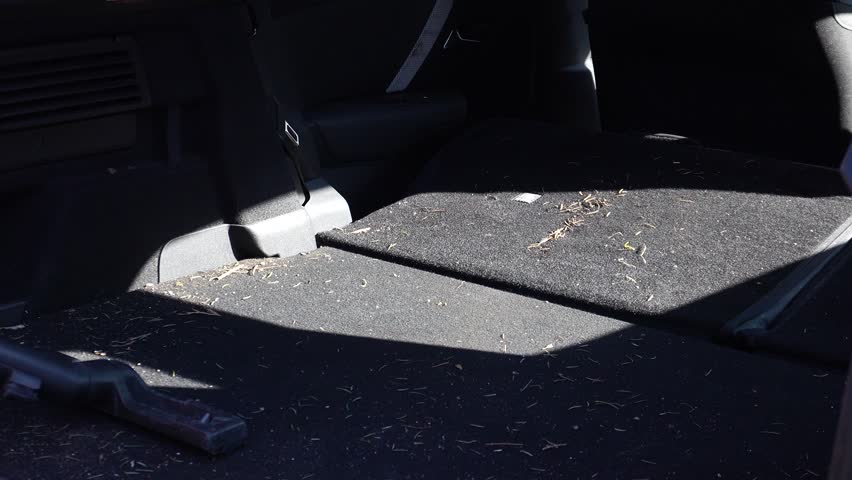 Car dry cleaning. Vacuuming the trunk of debris, removing small particles, and taking a close-up photo. Interior cleaning.