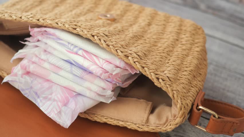 sanitary pad in a woman purse on table 