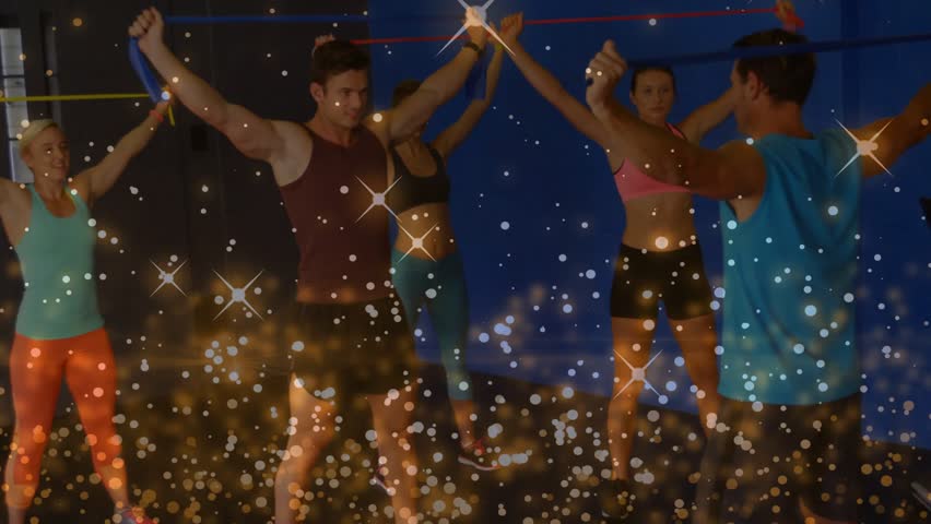 Trainer leading, group syncing squats and arm raises with bands for fitness, sparkle overlay rising. Resistance, band, overhead, studio, dynamic, rhythm, ensemble
