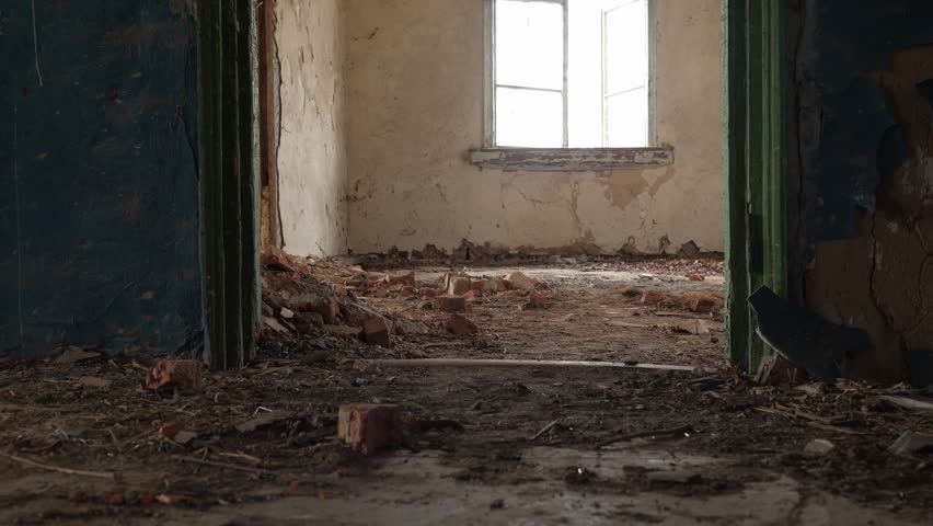 Person Walking Through Abandoned Dilapidated Room with Debris and Broken Bricks