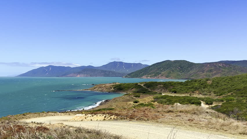 Cinematic view of turquoise Pacific coastline near Cooktown, Queensland, Australia. Tropical shore with clear blue water and natural coastal landscape in northern Australia.