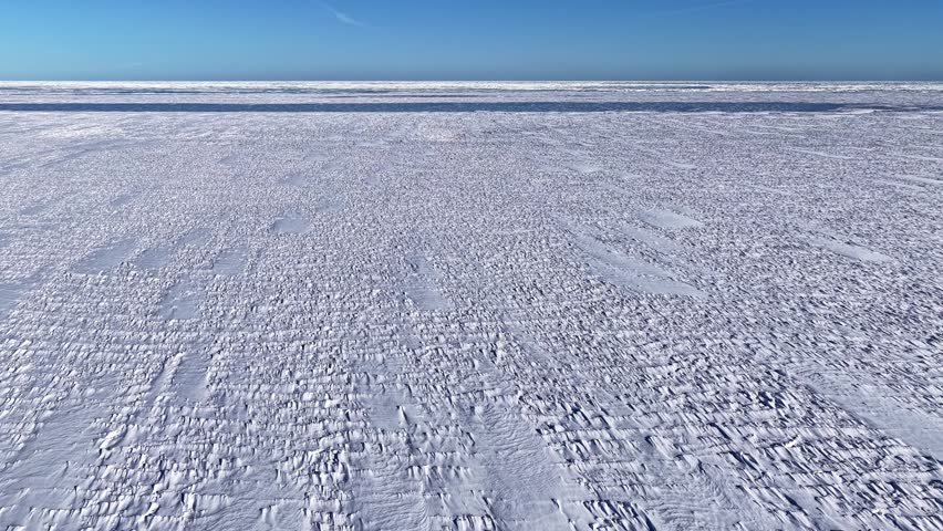 Frozen sea or lake surface with textured snow and ice, aerial empty cold winter backdrop