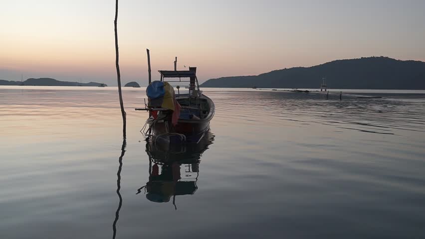 Longtail boats are docked along the beach in the morning