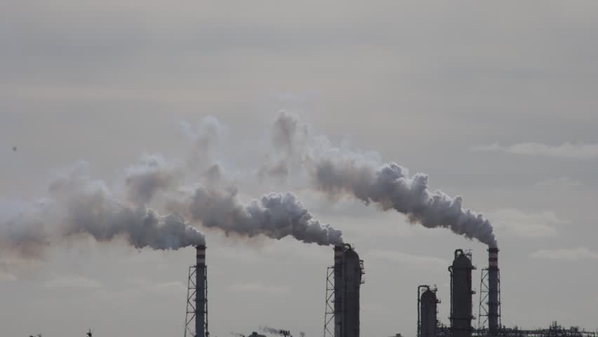 Air Pollution Concept - Industrial factory smokestacks billowing heavy smoke with sky background