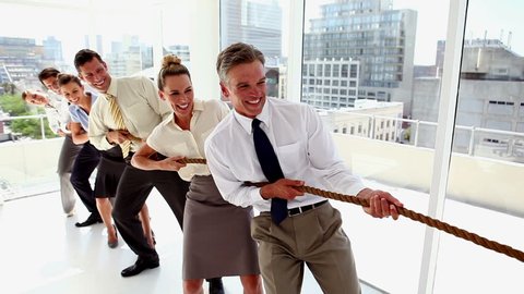 Business people pulling a rope together with motivation in the office
