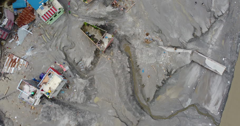 Top-down aerial view reveals the devastating impact of the Melamchi flood in Sindhupalchowk Nepal, with layers of silt burying houses and infrastructure in a remote mountain community.