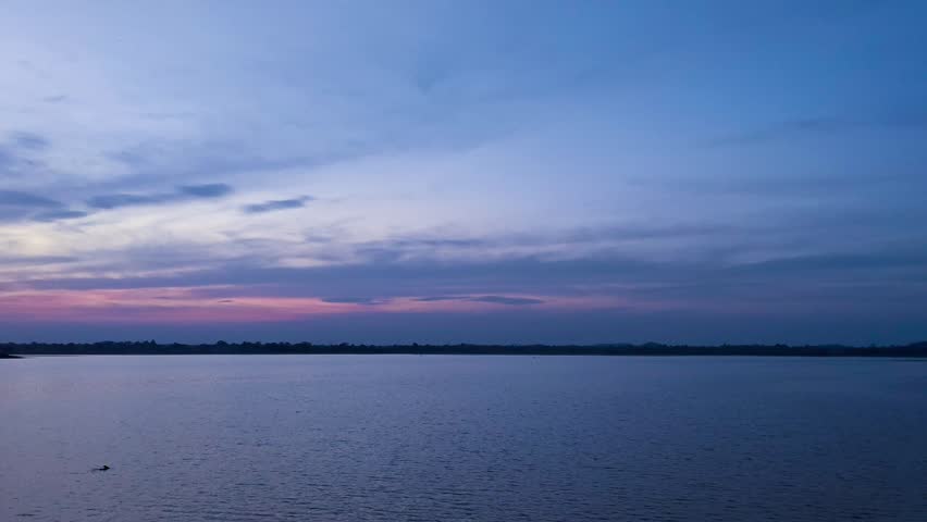 Serene sunset view over calm lake with purple and blue twilight sky