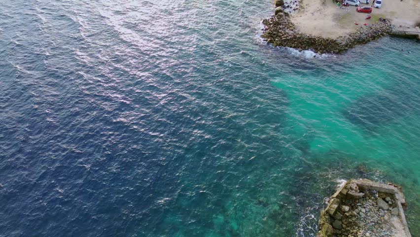 Aerial View of Blue Ocean and Turquoise Coastal Water with Rocky Shore